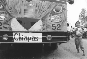 Pastors for Peace bus with child running beside it